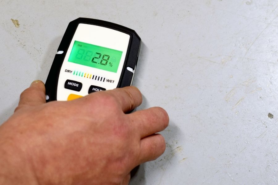 Technician documenting drying progress with moisture meter