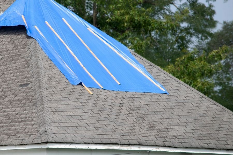 RestorePro technician tarping a storm-damaged roof in North-Central Ohio to prevent further water intrusion